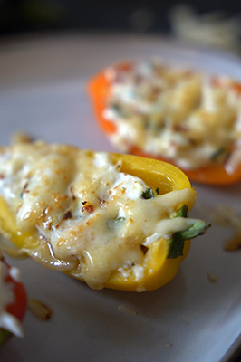 Stuffed mini sweet peppers with melted shredded cheese