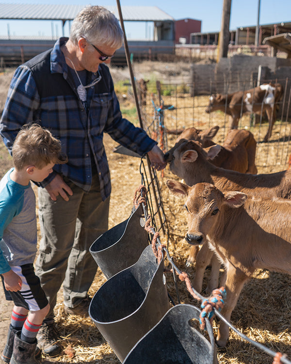 Owner Pat Ford and a child petting a calf