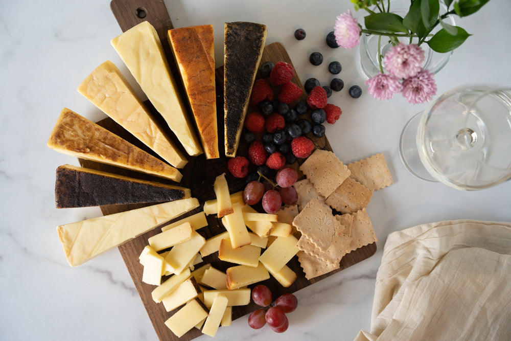 Cheese board with seven cheeses fanned out